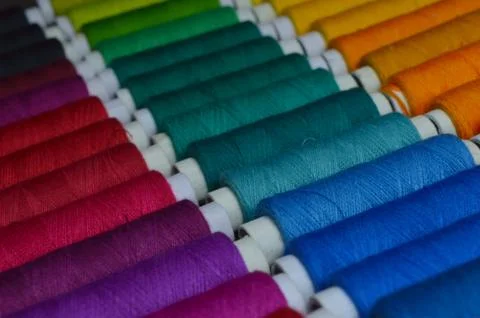 Colourful thread rolls arranged in a box. Some parts of the image are infocus Stock Photos