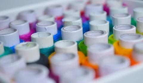 Colourful thread rolls arranged in a box. Some parts of the image are infocus Stock Photos