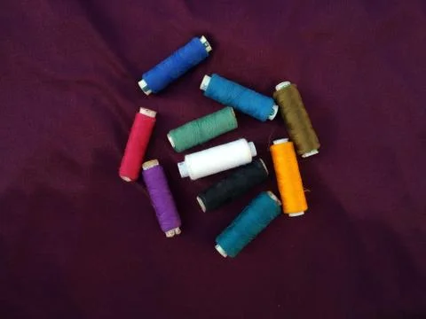 Colourful thread spools isolated on a violet background Stock Photos