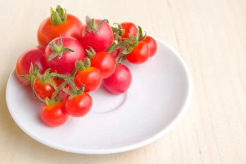 Colourful tomatoes on a white plate Stock Photos
