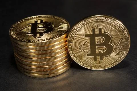 Column of bitcoins with one single coin next to them Stock-Fotos