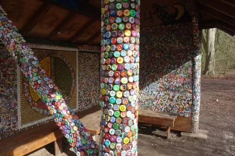 Column in sun made of thousands of tiny colorful bottle tops . funny wall art. Foto stock