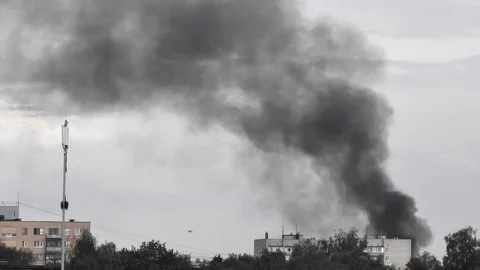 A column of thick black smoke rises above the city. Stock Footage 109388522