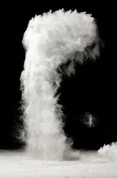 A column of white flour powder explodes and rises upward against a black ba.. Stock Photos