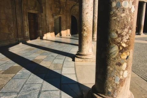 Columns casting shadows in the Charles V Palace at the Alhambra in Granada Stock Photos