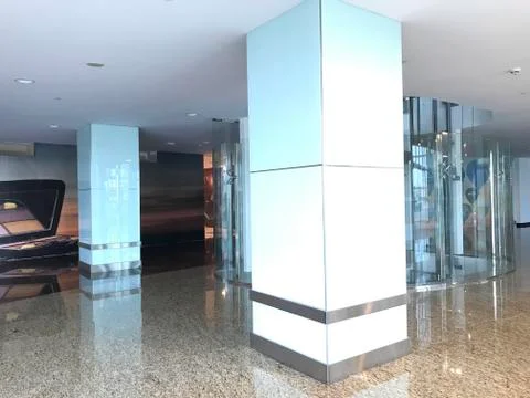 Columns with transparent glass cladding and stainless steel skirting with Gyp 库存照片