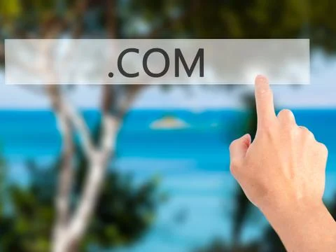 .COM - Hand pressing a button on blurred background concept on visual screen. Stock-Fotos
