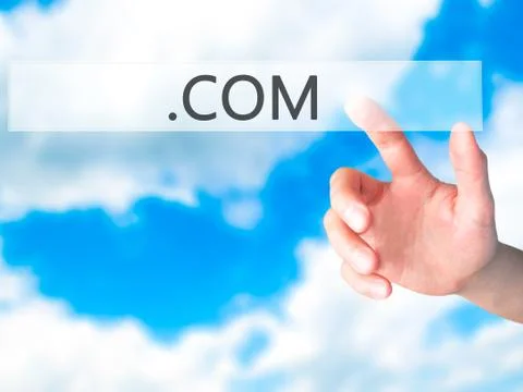 .COM - Hand pressing a button on blurred background concept on visual screen. Stock-Fotos