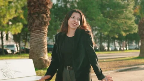Цoman spreading arms wide, joy while walking through park, celebrating freedom Stock Footage 299914308