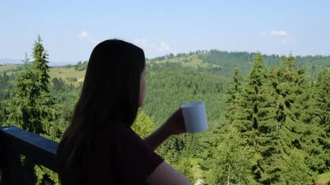 Цoman standing on outdoor balcony and drinking coffee on background mountains Stock Footage 159680112