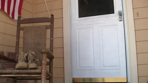 Combat boots on porch right to left trucking shot Stock Footage 10862325