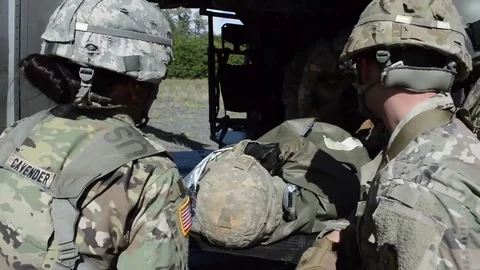 Combat Medics load casualty on stretcher onto Black Hawk Stock Footage 84636080