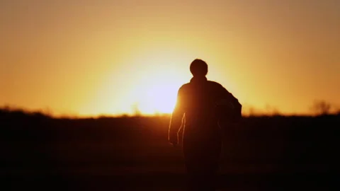 Combat Pilot Silhouette Walking Toward Camera at Sunset, Cinematic Backlight 4K Stock Footage 327991234