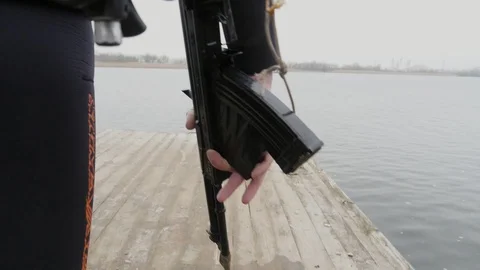 Combat swimmer with a machine gun in hands going on a wooden bridge in slo-mo Stock-Footage 121871312