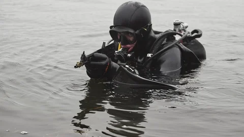 Combat swimmer turning his machine gun standing in a river in slow motion Stock-Footage 121905020