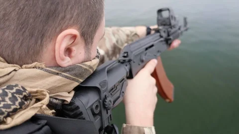 Combatant controls patrol zone with assault rifle, talks radio, moves. Video stock 117220111
