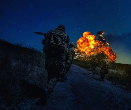 Combatants team attacking enemy at night Stock Photos