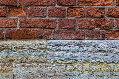 Combinated wall of red bricks and limestone blocks. Abstract texture Stock Photos