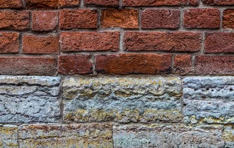 Combinated wall of red bricks and limestone blocks. Abstract texture Stock Photos