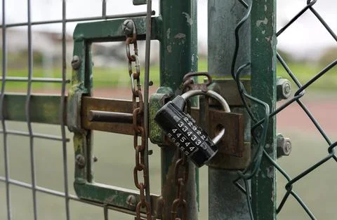 Combination Padlock and Chain Securing Chain-Link Fence Gate Stock Photos