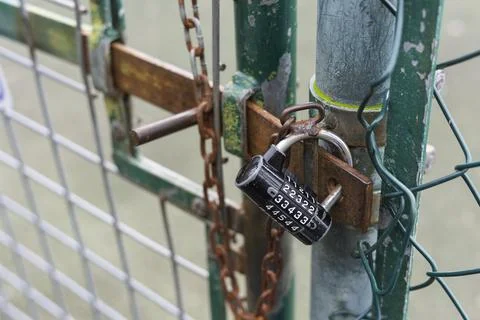 Combination Padlock and Chain Securing Chain-Link Fence Gate Stock Photos