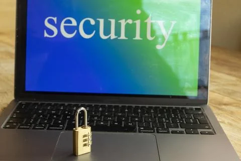 Combination padlock on laptop keyboard with security text on screen Stock Photos