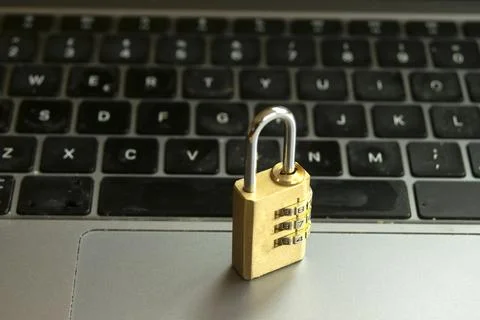 Combination padlock resting on a silver laptop keyboard Stock Photos