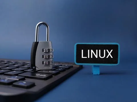 A combination padlock rests on a black keyboard next to a LINUX sign on a b.. 写真素材