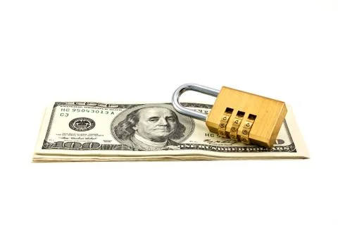 A combination padlock shot over stack of US Dollars banknotes Stock Photos