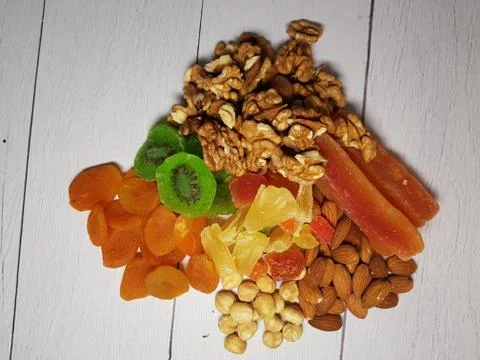 A combination of various nuts and dried fruits and a white wooden table, top Stock Photos