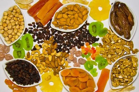 A combination of various nuts and dried fruits and a white background from ab Stock Photos