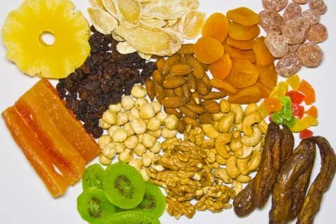 A combination of various nuts and dried fruits and a white background from ab Stock Photos