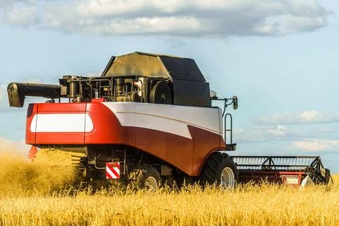 Combine harvester with ?utter platform at work. Reaping machine. Stock Photos