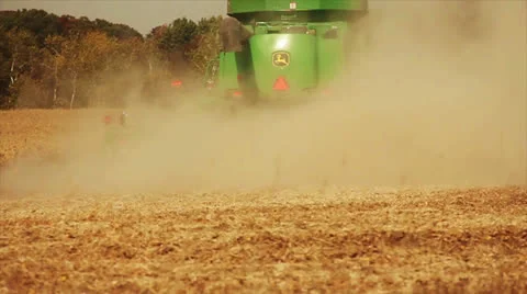 Combine Moving Away Through a Wheat Field Kicking up Dust Video stock 22461837