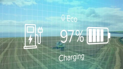 Combine working in field under overlay showing Eco, Charging label, plug icon, Stock Footage 333965076