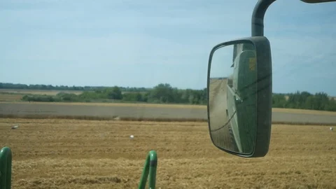 Combine working at wheat field, rearview mirror Stock Footage 123733213
