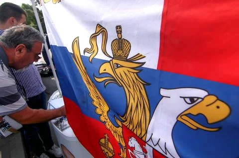 Combined Serbian Russian flag with eagle emblems at political rally Stock Photos
