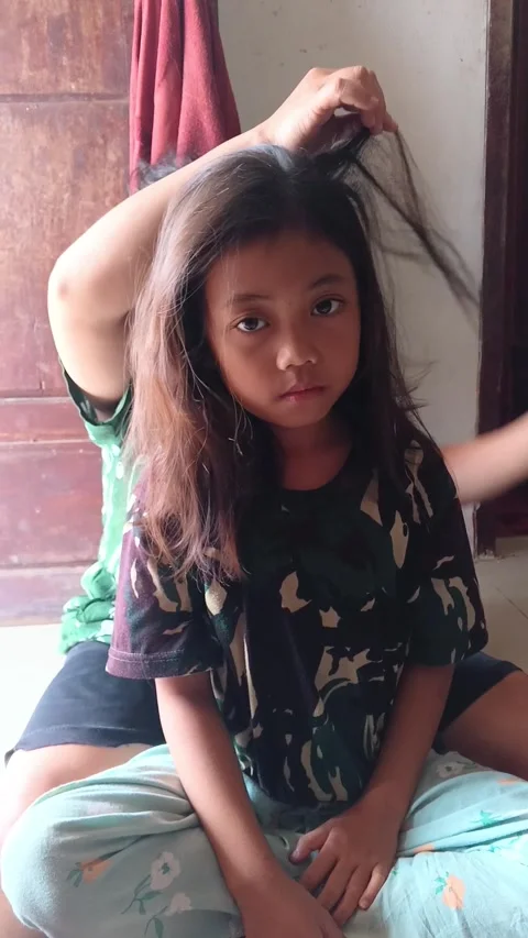 Combs her hair for lice. Stock-Footage 335019557