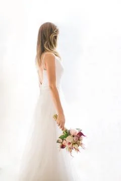 Come in front of the white background. She has a bridal flower in her hand. Stock Photos