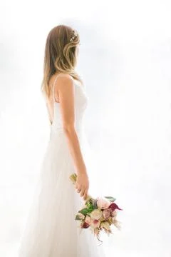 Come in front of the white background. She has a bridal flower in her hand. Stock Photos