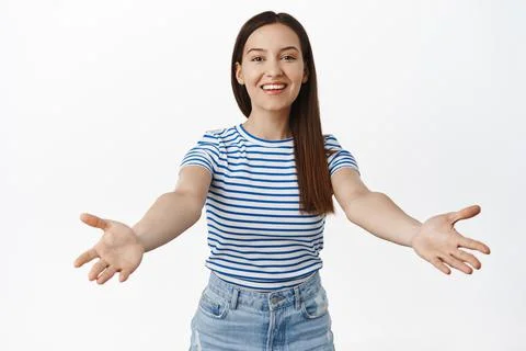 Come here. Smiling friendly 20s girl spread her arms for hug, warm welcome Foto stock