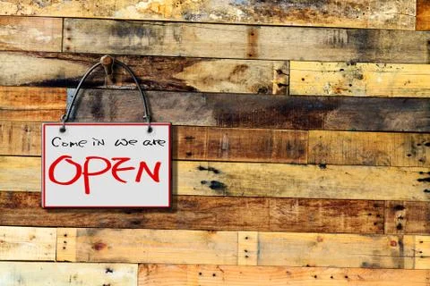 Come in we are open hanging sign isolated on wall Stock Illustration