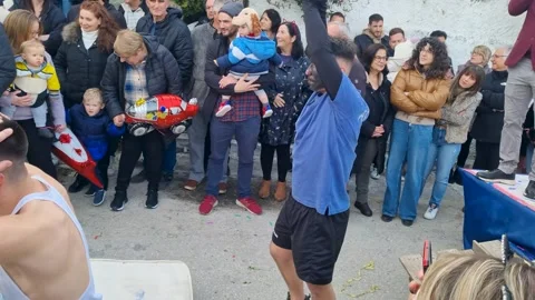 Comedic athletic jump parody performance with a cheering crowd, presenters, and 動画素材 332952368