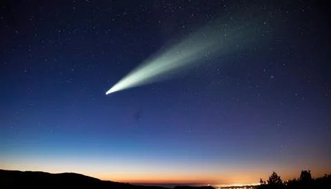 A comet is an icy, small Solar System body that warms and begins to release.. Stock Photos