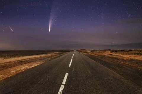 Comet over the old asphalt road in the desert. Stock Photos