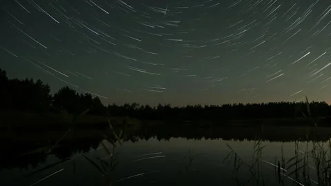 Comet-shaped star trails in the night sky over the lake Stock-Footage 250315971