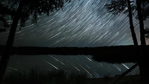Comet-shaped star trails in the night sky over the lake Stock-Footage 252068288