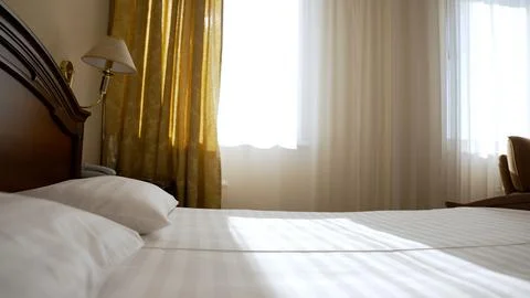 Comfortable bed and bright windows. Elegant bedroom with floor to ceiling w.. 스톡 사진
