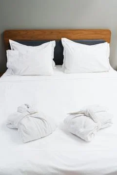 Comfortable Bed With Bathrobes For Bedtime Rest And Spa Relaxation Stock Photos