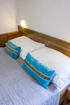 Comfortable bed with two pillows and a gray blanket in a modern bedroom Foto stock
